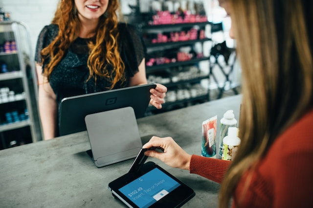 Woman swiping her credit card on a terminal